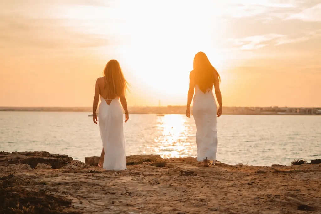 Two women walking at sunset